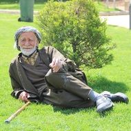 Old Muslim resting on the grass