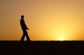 Silhouette of the person against the light on the horizon