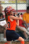 girl with a bat and a helmet in softball