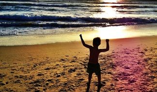 child on the beach of the ocean at dusk