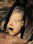 large clay sculpture near a tree