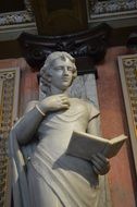 statue of a woman with a book in a museum