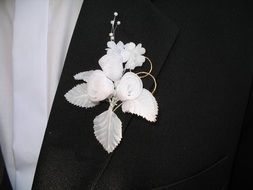 white brooch on a suit of the groom