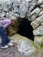 Child boy looking at window in stone wall