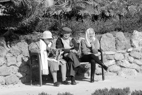 old people relaxing on a bench on a sunny day