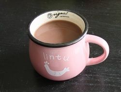 brown Hot beverage in pink Mug on black table