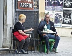 elderly couple at a table outside in italy