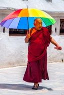 buddhist monk with a colorful umbrella