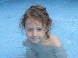 curly girl in swimming pool
