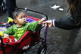 Asian Baby Boy in a colorful carriage with toys outdoors in New Orleans