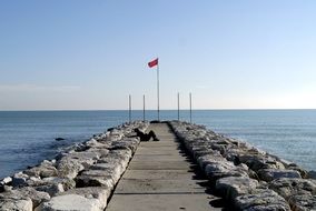 Old Man lays on pier at Sea
