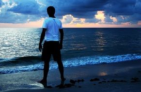 back view of posing man on the sea beach