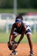 young woman playing softball on blurred background
