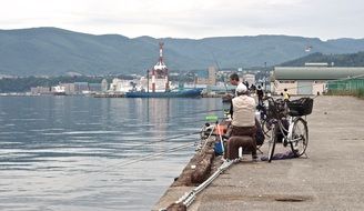 people are fishing on a pier in Japan
