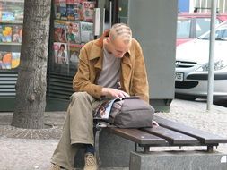 young man with a fashionable hairstyle reads a magazine in Prague, Czech Republic