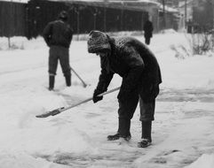 black and white photo of how people remove snow in winter