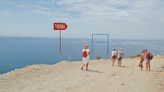 people on the beach by the sea in greece