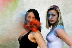 portrait of Colorful powder falling on a Two girl friends