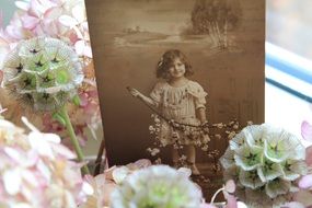 Nostalgia, vintage photo of child girl and flowers