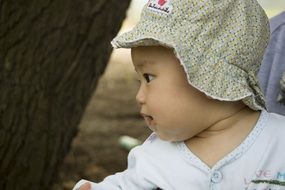 Cute baby girl near the tree