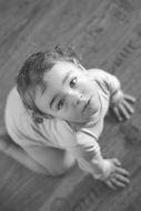 charming baby on the floor in black and white image