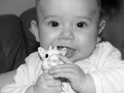 black and white picture of a baby with giraffe