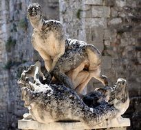 Old statue of dragon man close-up on blurred background