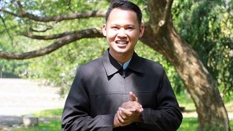 happy man standing near a tree