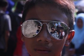 dark-skinned boy in mirror glasses