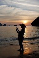 silhouette of a photographer on the beach at sunset, thailand