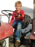 photo of a boy on a red tractor