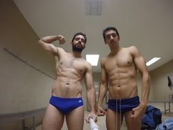 two Male Athletes posing in changing room