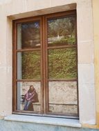 Mirroring of girl Sitting in park on Window