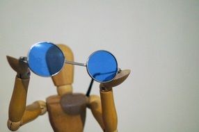 blue glasses on the background of the wooden man