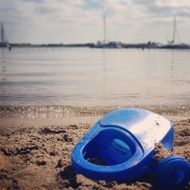 blue watering can on the beach