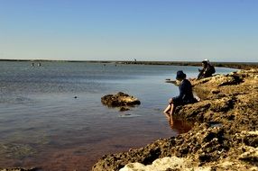 people on the rocky shore