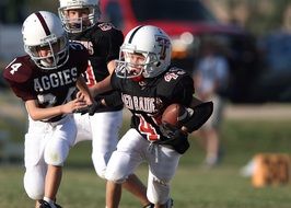 children in helmets play American football