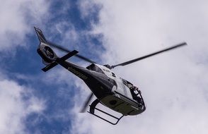 helicopter in flight in the sky with white clouds