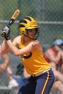 woman in helmet playing softball on a blurred background