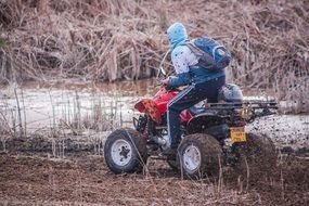 the guy rides a Quad bike near the water