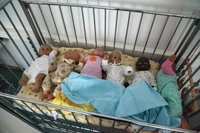 dolls like children in a crib