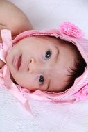 photo of a newborn in a pink cap