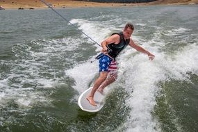 wakesurfing is riding behind boat