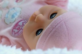 cllseup picture of toy baby doll in pink clothes