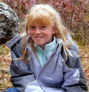 Ginger Child Girl with Freckles on Face sits outdoor