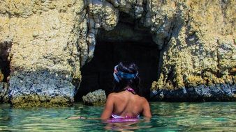 girl swimming near the sea cave