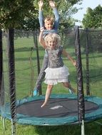 two children in a trampoline among nature