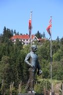 Sculpture of a man next to the flags in Norway