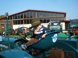 little child on a vintage tractor in a museum