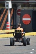 child on kart on the road with signs